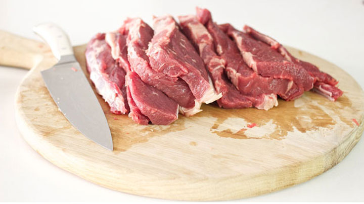 Topside beef cut into strips on a wooden board