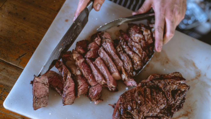 medium rare steak sliced on a marble chopping board